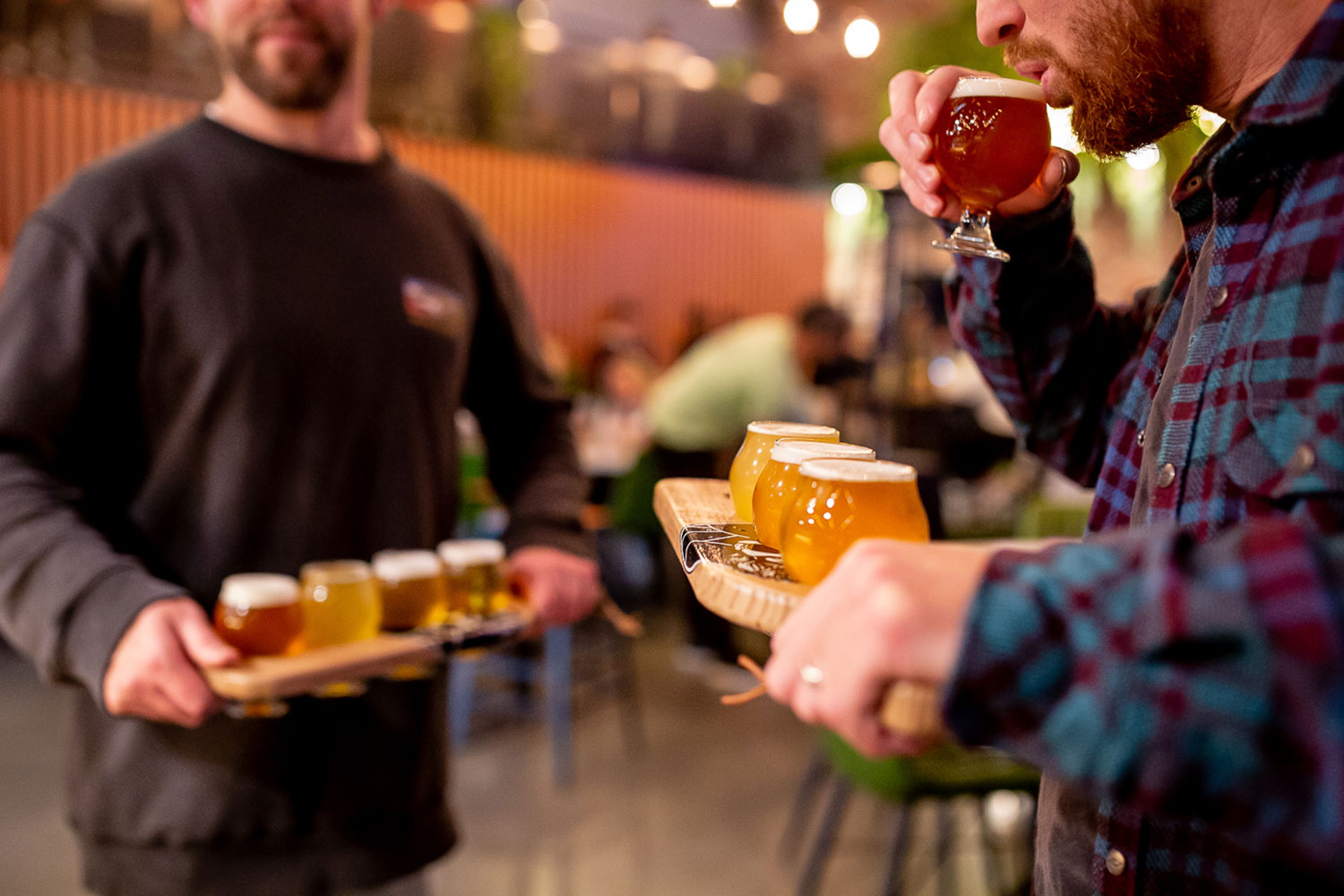 Men holding a tasting paddle full of mini tulips craft beers