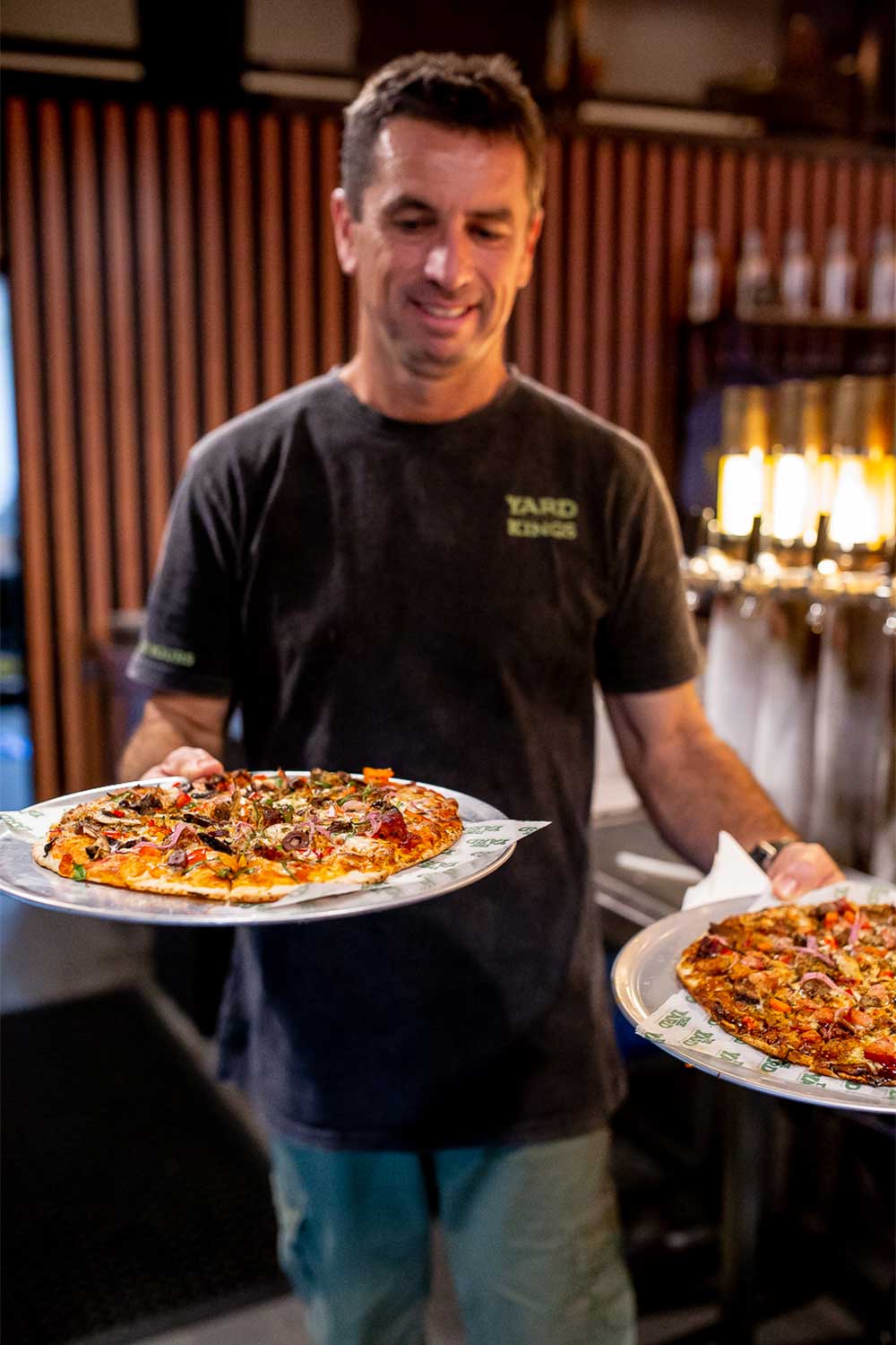 Waiter serving pizza at a brewery